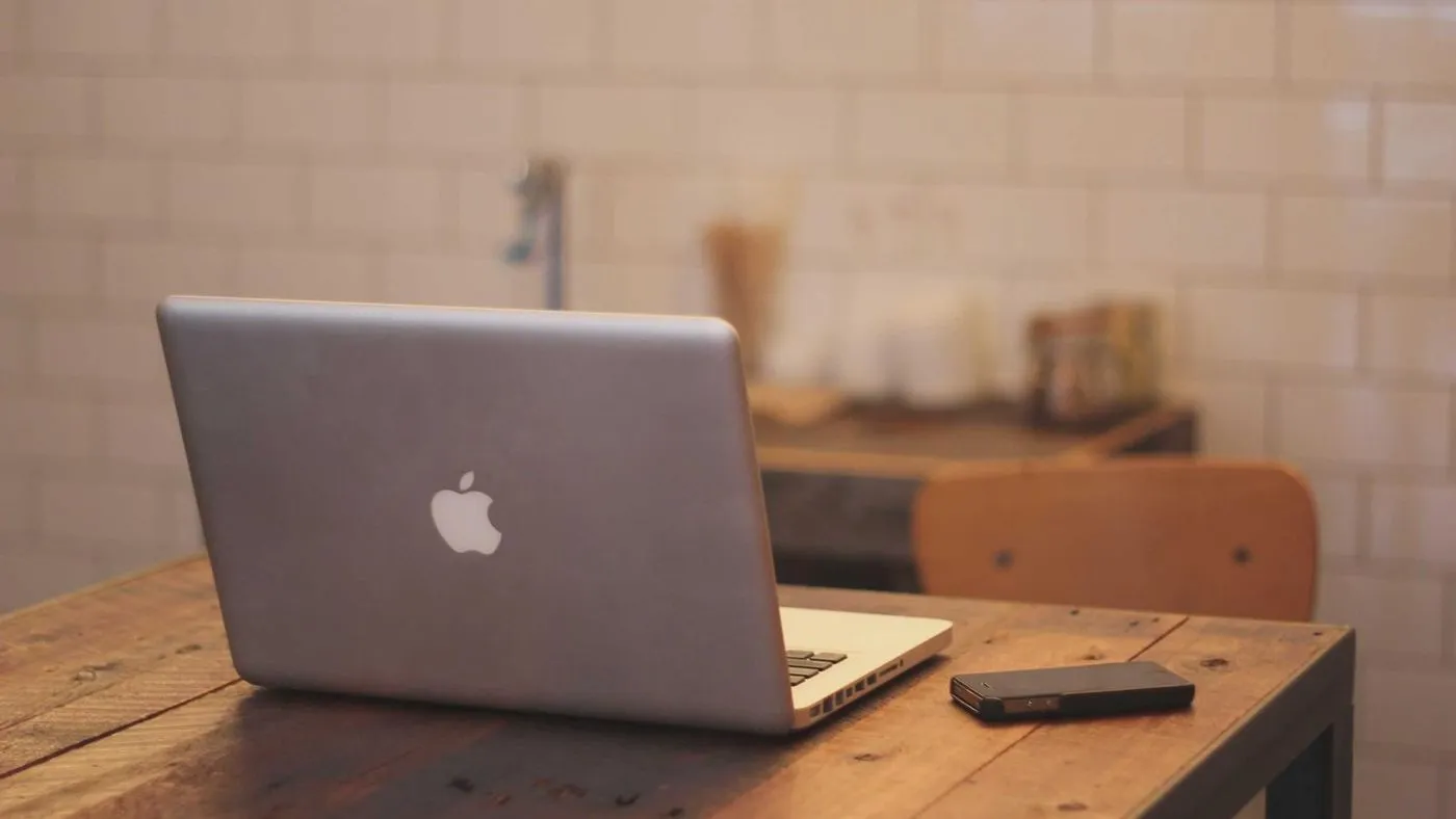 Un portatile aperto su un tavolo di legno in una cucina luminosa