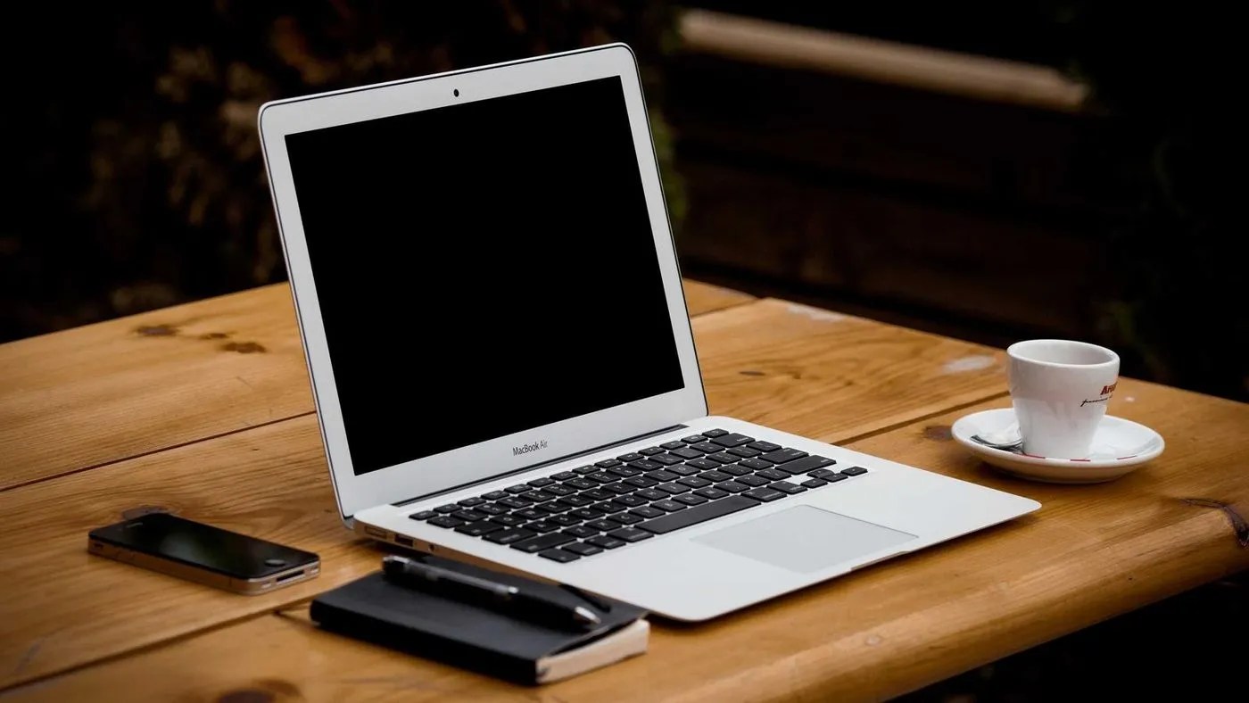 Un portatile aperto su una scrivania di legno