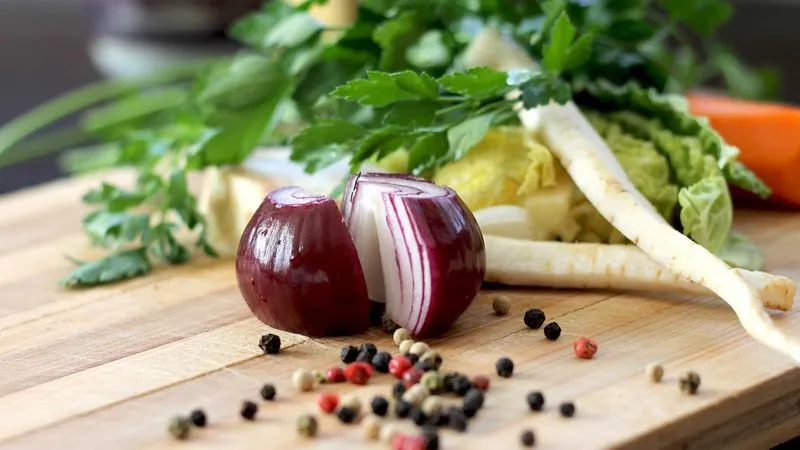 Verdure fresche e spezie su un tagliere di legno